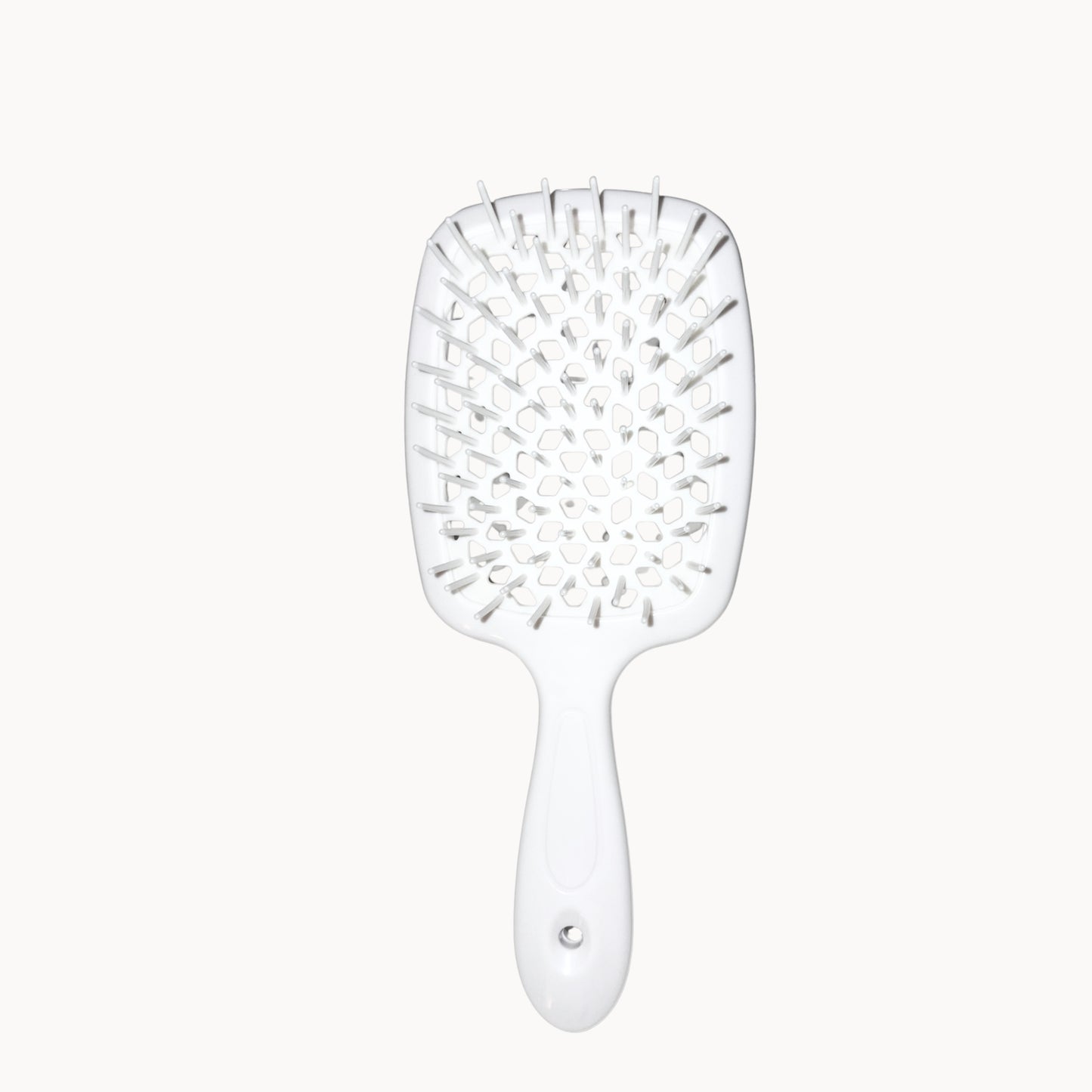 White paddle hairbrush on a white background