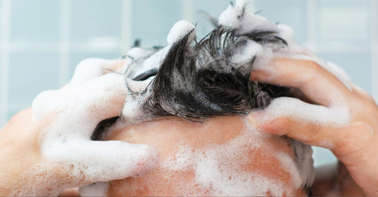 Closeup of man washing his hair with shampoo