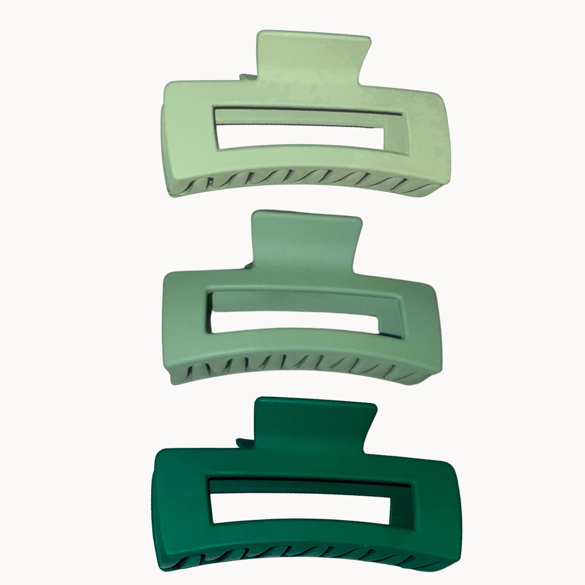 Set of three green hair clips on a white background