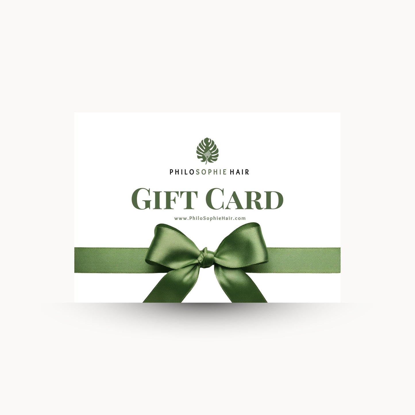 Philosophie Hair gift card with a green ribbon on a white background