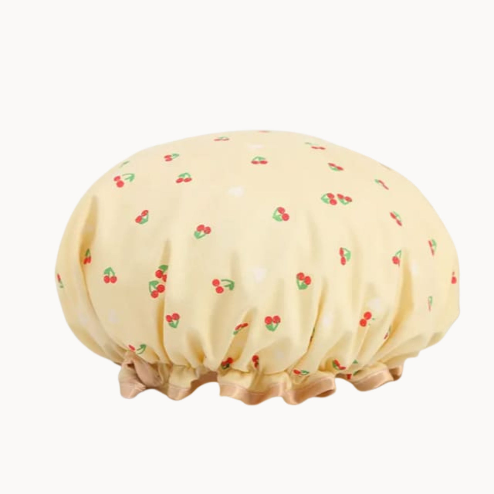 Yellow shower cap with cherry pattern on a white background