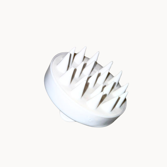 White scalp massager with pointed bristles on a white background