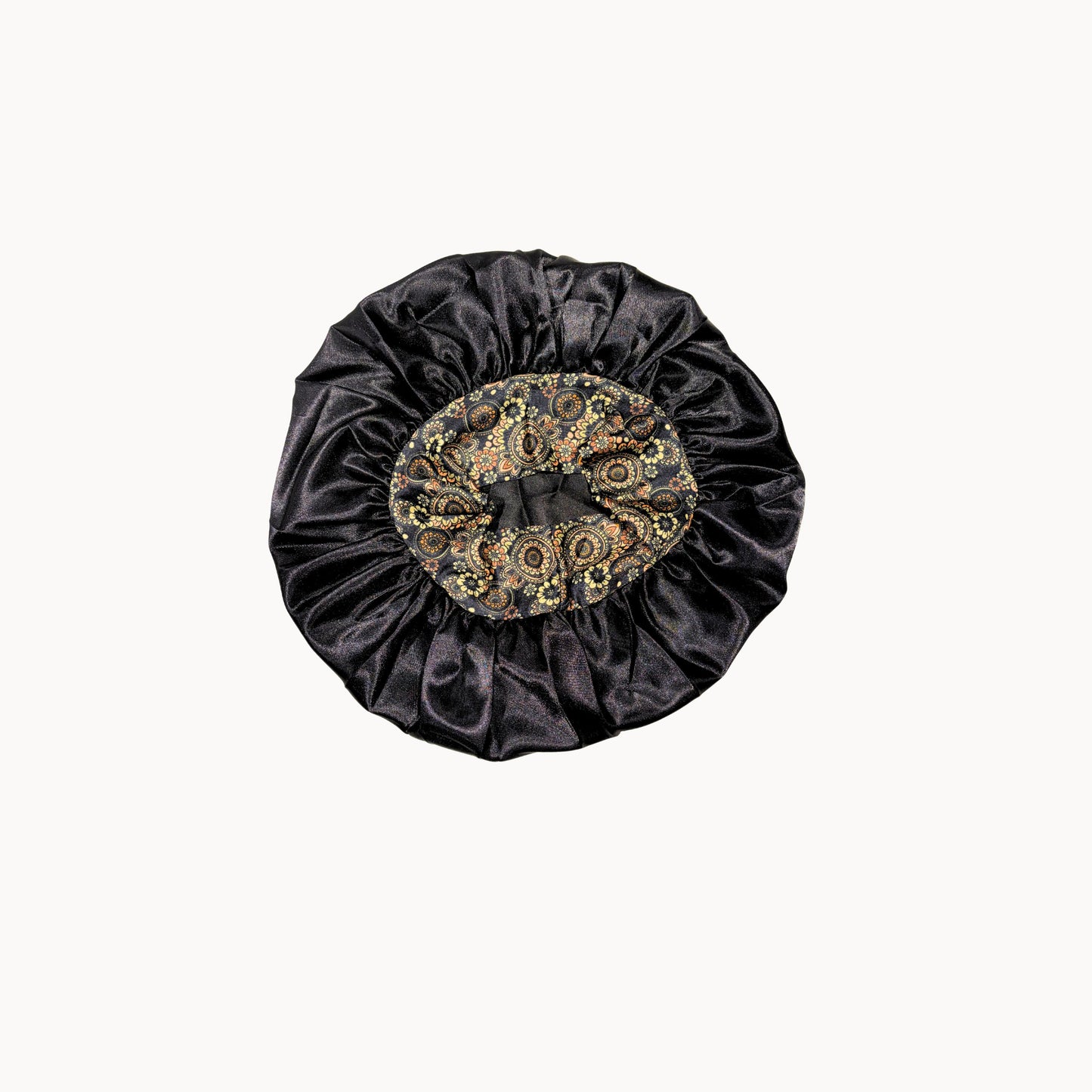 Black satin bonnet with intricate gold pattern on a white background